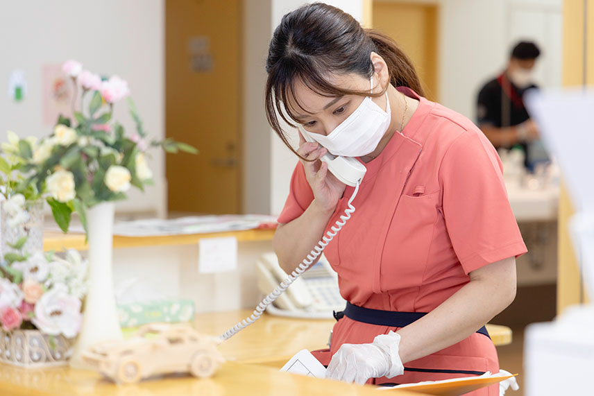 電話で他のセクションとやり取りする看護士